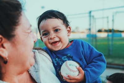 选择聚焦婴儿拿着棒球的照片
